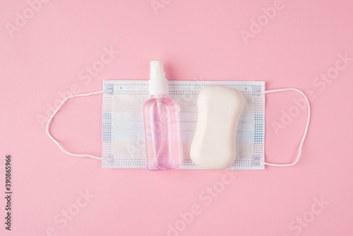 Top above overhead close up view flat lay photo of mask soap and sanitizer isolated on pastel pink color background with copyspace