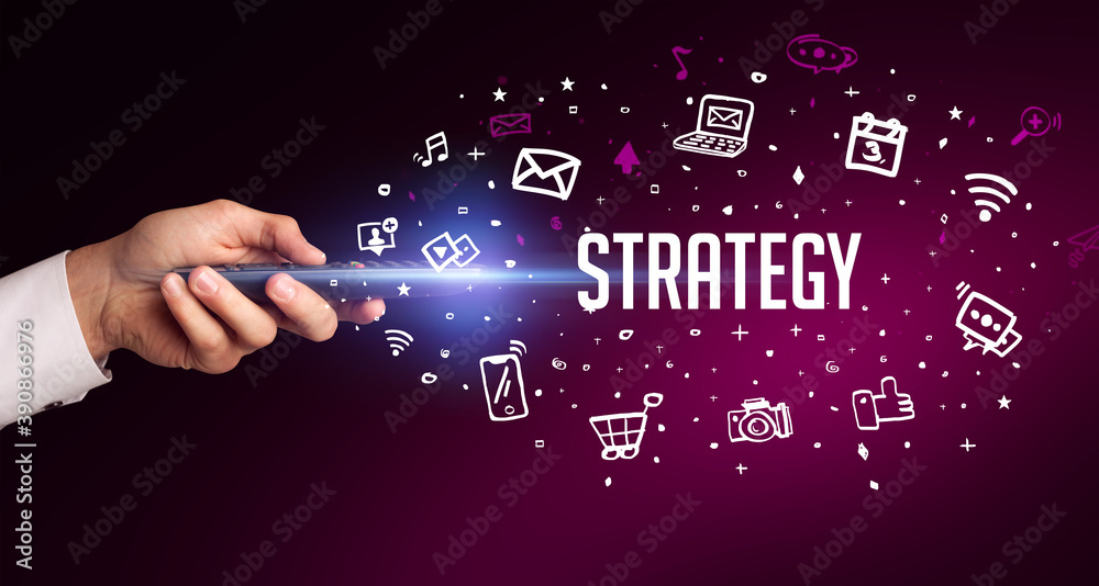 hand holding wireless peripheral with STRATEGY inscription, social media concept hand holding wireless peripheral with STRATEGY inscription, social media concept