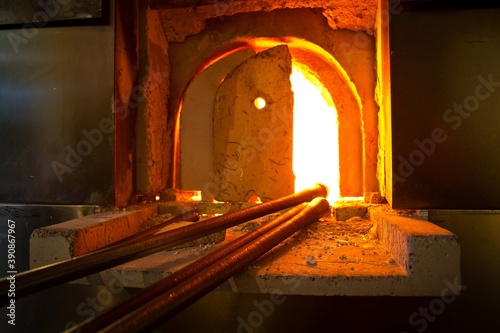 Stove with bright burning fire and equipment in front of it in glassblower workshop. Finland, Helsinki.