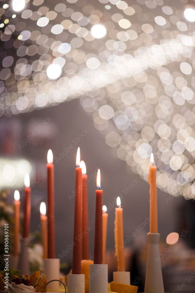 Close up of many burning candles standing on wedding table Close up of many burning candles standing on wedding table