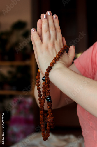 Woman hands holding rudraksha rosary with the namaste mudra. photo