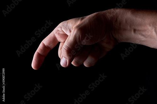 Index finger down, on a black background contrasting and gloomy image