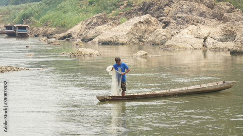 Bamboo Bridge over Nam Khan river in a lush tropical landscape in Luang Prabang, Laos.