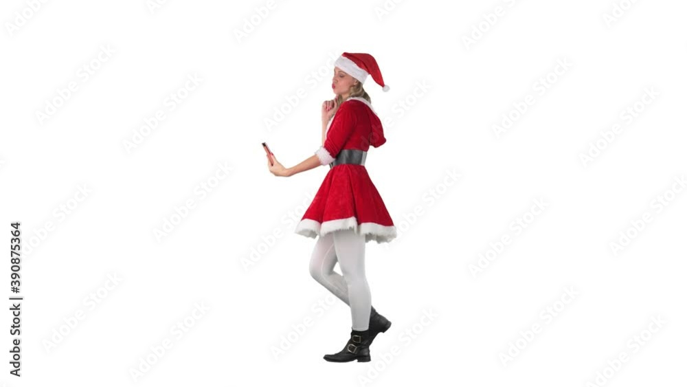 Side view of cheerful young Santa woman taking selfie photos or video chat on cell phone. Full body isolated on white background. Side view of cheerful young Santa woman taking selfie photos or video chat on cell phone. Full body isolated on white background.