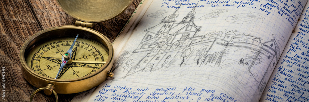 Vintage brass compass and old travel journal with handwriting and pencil sketches (property release attached), travel concept.