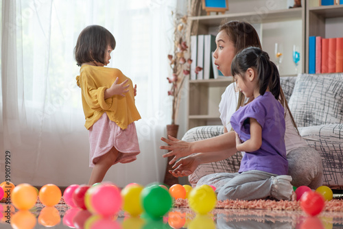 Asian family mother and child daughter are playing colorful balls