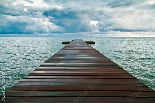 A wooden pier in blue sea and big clouds over it in Budva  Montenegro.