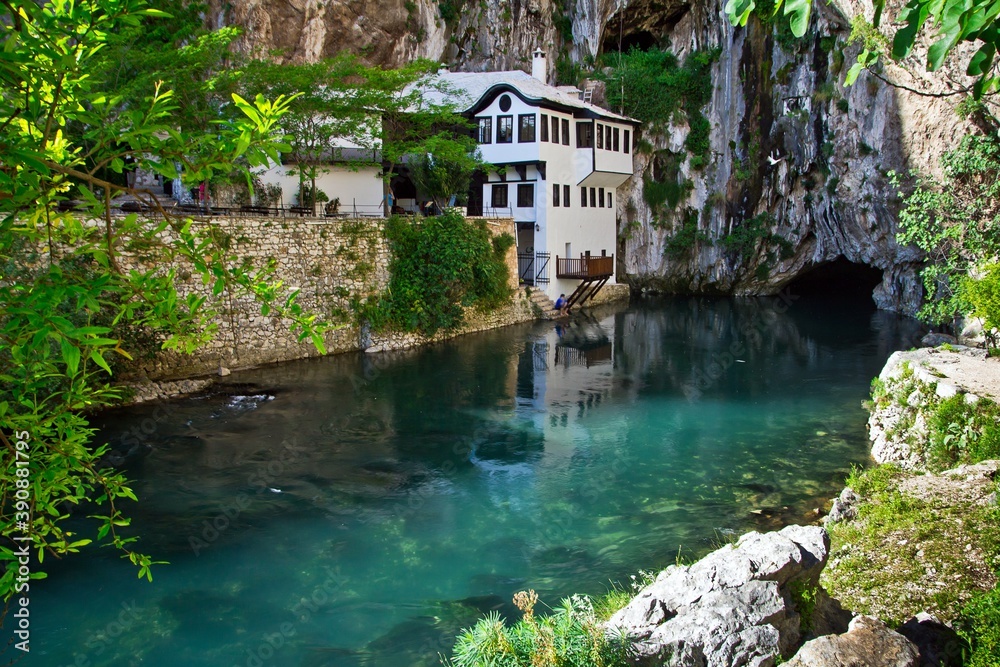 Dervish house on Buna spring with a small waterfall and a cave nearby in a sunny summer day in Blagaj, Bosnia and Herzegovina.
