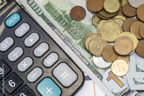 black calculator and money in the form of dollars and coins. the concept of savings.business concept