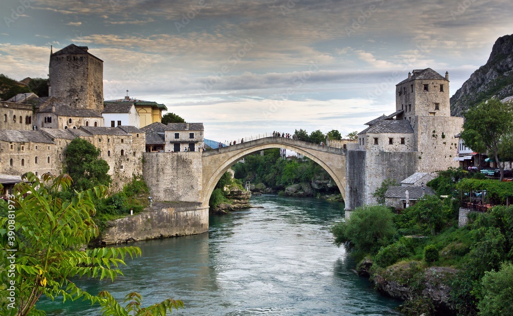 View on Mostar city with old bridge (Stari Most) over the Neretva river and other white stone buildings in Bosnia and Herzegovina.