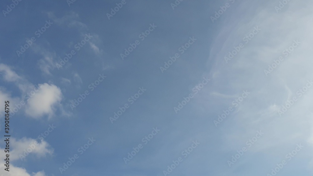 white clouds disappear in the hot sun on blue sky. Time-lapse motion clouds, blue sky background and sun