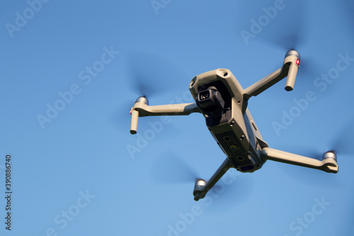 Gray mini quadcopter on a blue sky background