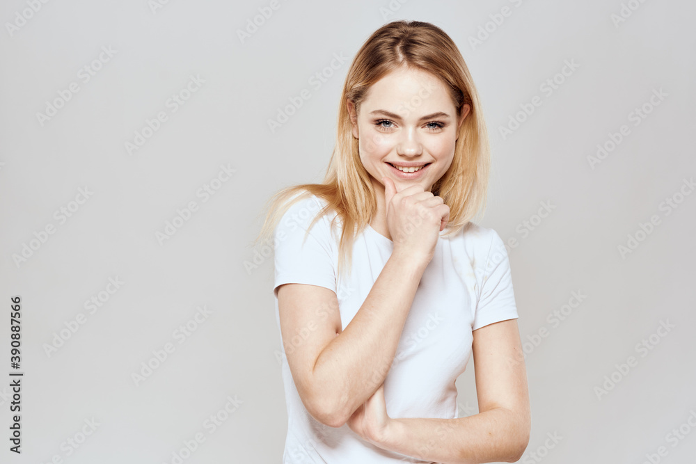 Cute blonde white t-shirt gesture with hands lifestyle light background Cute blonde white t-shirt gesture with hands lifestyle light background