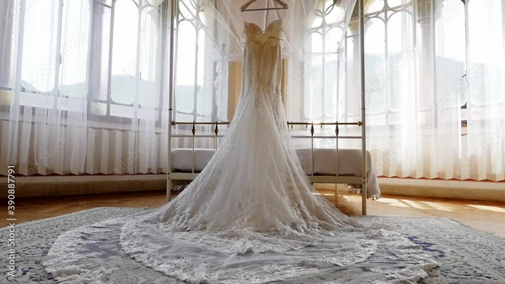 Beautiful modern wedding dress hanging in a luxurious room