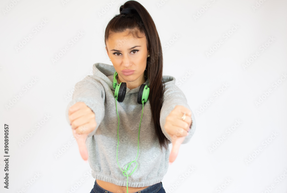 Young woman in sport clothes isolated on white background showing thumbs down. Young woman in sport clothes isolated on white background showing thumbs down.