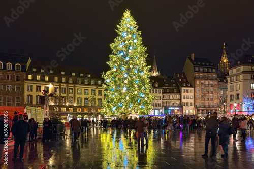 Obraz na płótnie Strasbourg, France. The city's main Christmas tree on Place Kleber. It has traditionally imposing height, at least 30 meters. Tower of Strasbourg Cathedral is visible at the right border of the image. w salonie