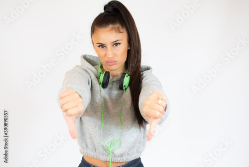 Young woman in sport clothes isolated on white background showing thumbs down.
