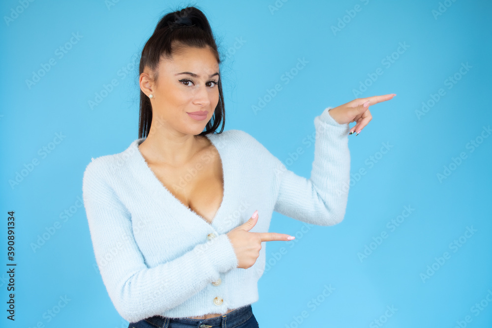 Young woman over isolated blue background pointing finger to the side Young woman over isolated blue background pointing finger to the side
