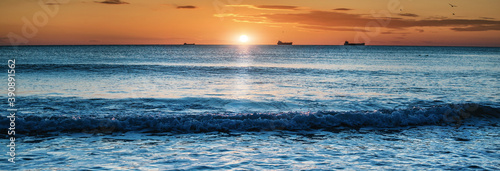 Blue sea at sunset and many ships photo