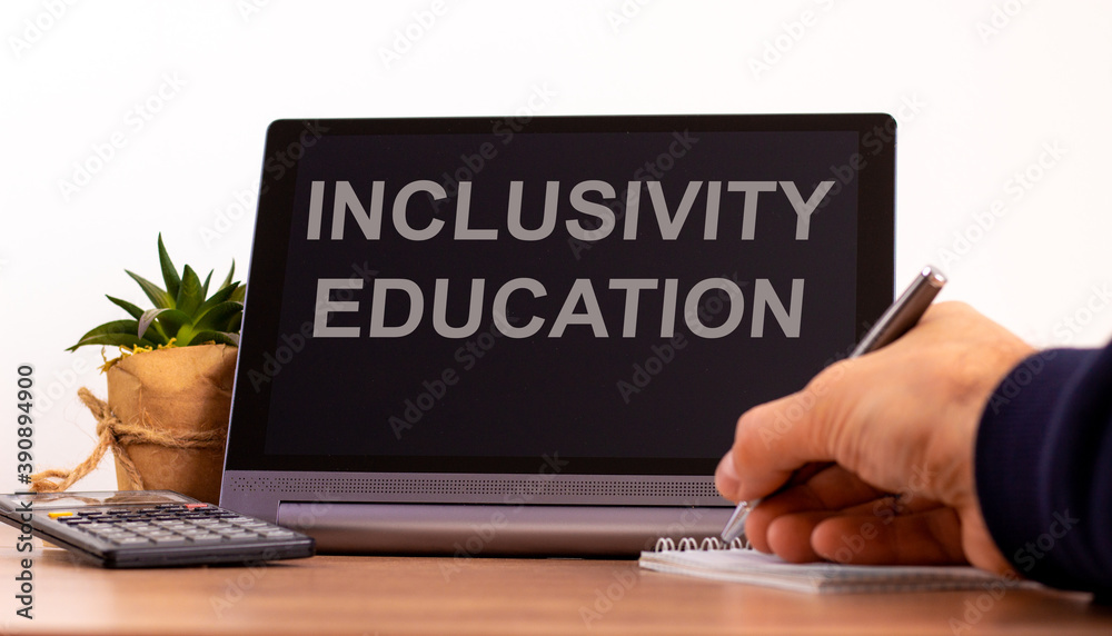 Education and inclusivity concept. Tablet with text 'inclusivity education'. Online education during COVID-19 quarantine. Male hand with pen, calculator, copy space. Education and inclusivity concept. Tablet with text 'inclusivity education'. Online education during COVID-19 quarantine. Male hand with pen, calculator, copy space.