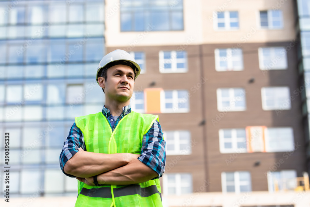 Building, construction and people concept. Close up of builder crossed hands in front of constraction Building, construction and people concept. Close up of builder crossed hands in front of constraction