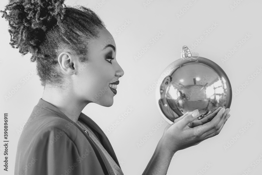black and white portrait of cheerful afro american woman holding in her hands christmas bauble decoration. Christmas, new year, happiness, holidays concept black and white portrait of cheerful afro american woman holding in her hands christmas bauble decoration. Christmas, new year, happiness, holidays concept
