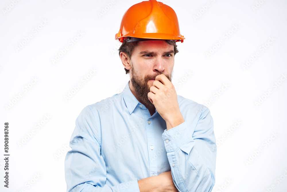 A man in a working uniform orange hard hat gestures with his hands emotions Construction engineer Professional A man in a working uniform orange hard hat gestures with his hands emotions Construction engineer Professional