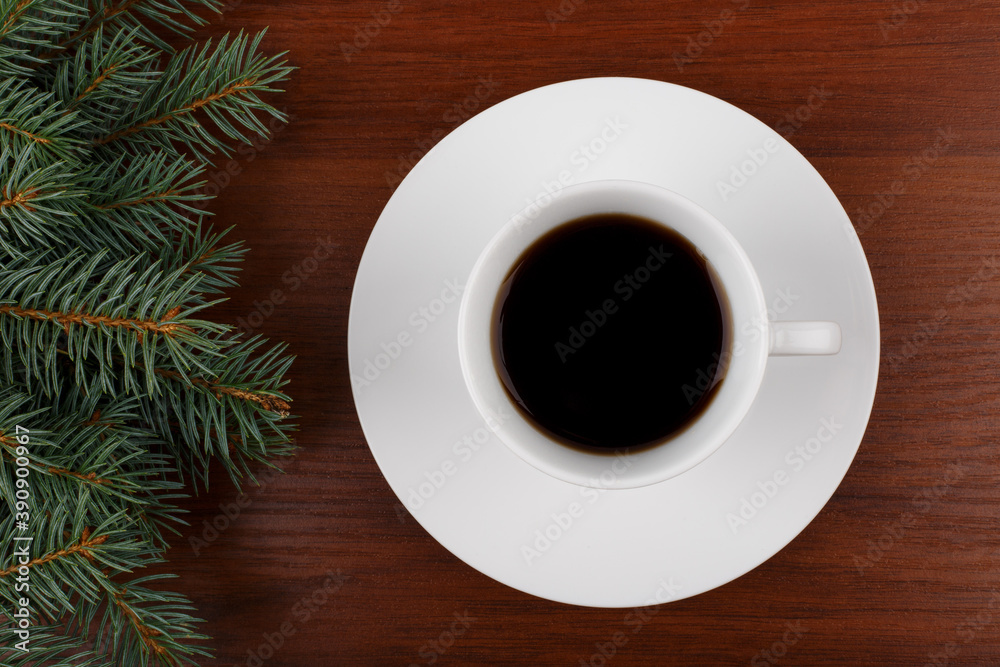 Cup of coffee on wooden table with Christmas tree at the left corner Cup of coffee on wooden table with Christmas tree at the left corner