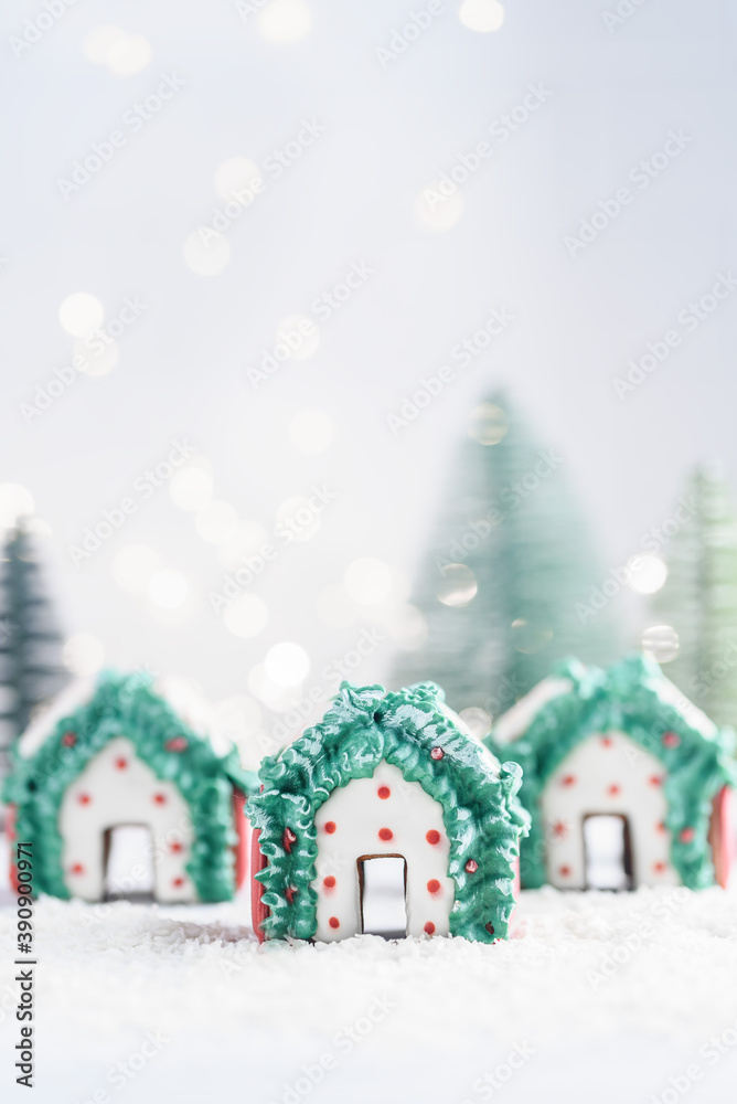 Three Christmas gingerbread houses on white snow. Selective focus.