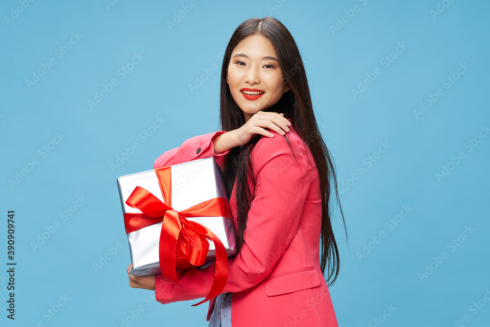 Woman with gift in hands holiday pink jacket birthday smile blue Woman with gift in hands holiday pink jacket birthday smile blue