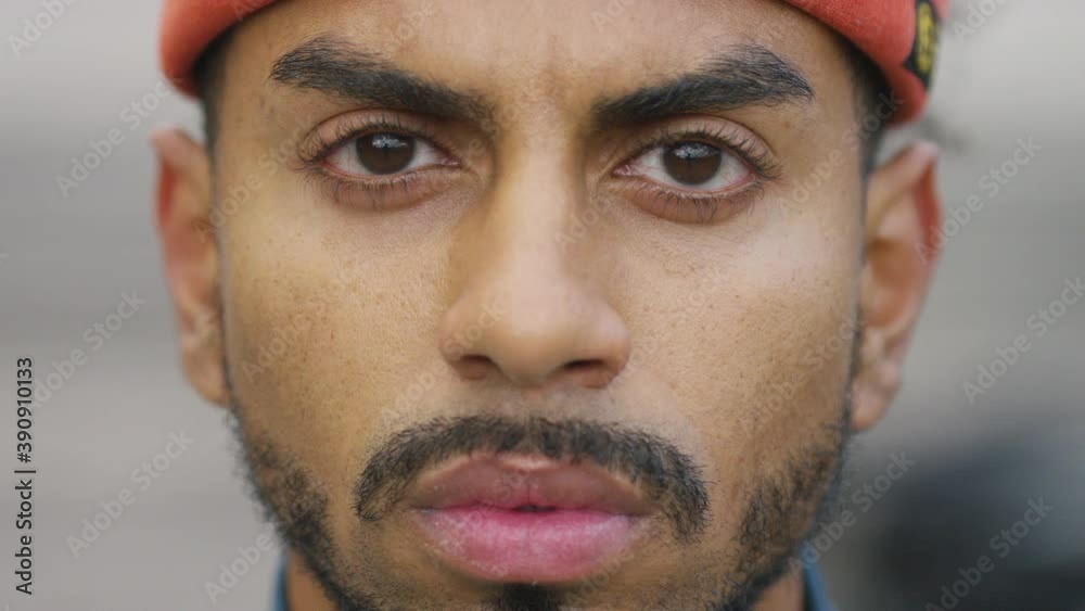 Close up portrait of young black male looking to camera with no expression 