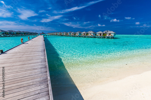 Jetty over atoll and a tropical resort island in Maldives © Martin Valigursky