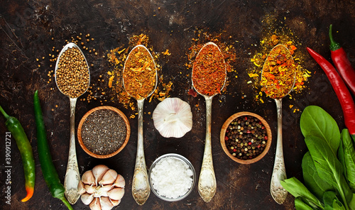 Fototapeta Naklejka Na Ścianę i Meble -  A variety of spices and herbs on a dark table. Cooking background. View from above. Ingredients for cooking. Table background menu. Copy space.