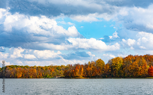 Brightly colored trees of autumn line the shore of Worster Lake at Potato Creek State Park in North Liberty, Indiana photo