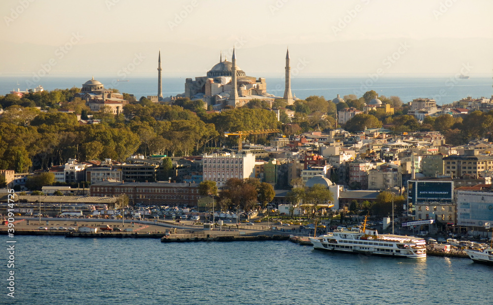 Hagia Sophia and Eminonu pier in the same frame during sunset. At the back of the peninsula, ships are passing. Entrance of Golden Horn.