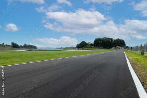 Asphalt straight track empty and green field on motor sport circuit