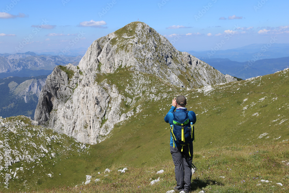 Man taking photo of mountain peak