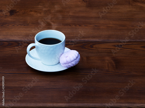 White cup of coffee and pink zefir on the wooden background. Traditional russian sweets like marshmallow. Copy space.