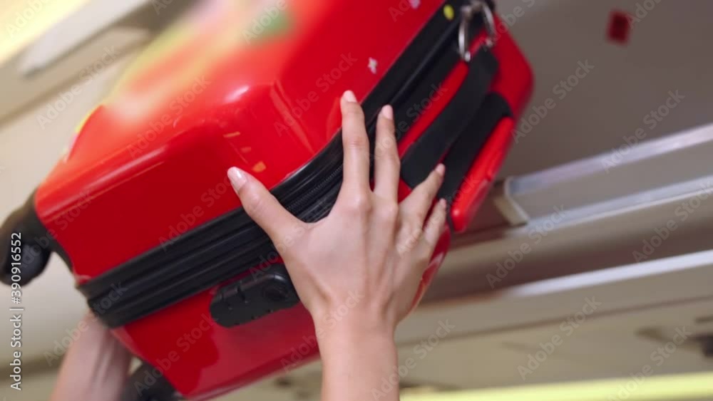 Cabin crew lift luggage bag in airplane . Airline transportation and