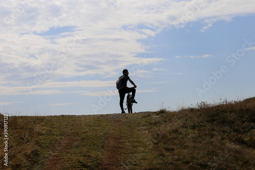 silhouette of a biker on a hill © Nedim