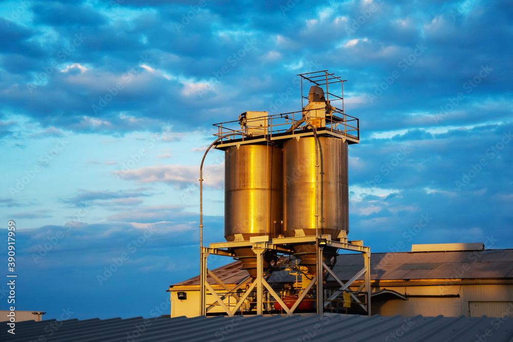 Obraz premium storage tanks made of metal cylindrical shape on the roof of an industrial building.Oil storage tanks at a petrochemical plant. Petroleum products processing plant. Industrial view of the factory area