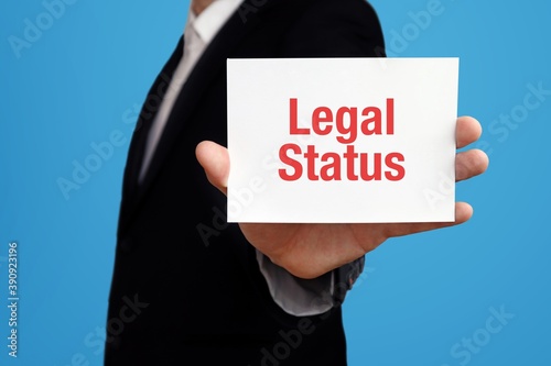 Legal Status. Businessman in suit showing business card with text. Man isolated on blue background