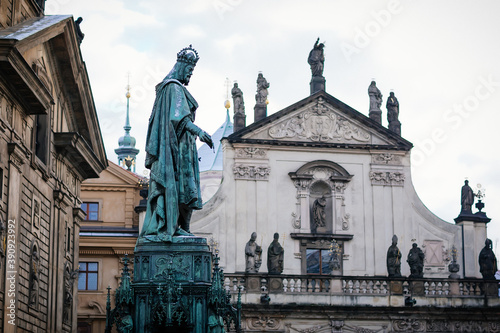 Bronze statue of king Charles IV and Church of the Blessed Savior on Crusader Square near Charles Bridge in winter, Old Town of Prague, Czech Republic