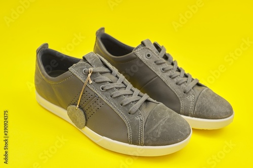 New men's leather gray sneakers on yellow background, top view