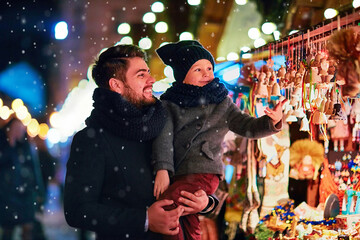 smiling father and son having fun at the christmas market during winter holidays