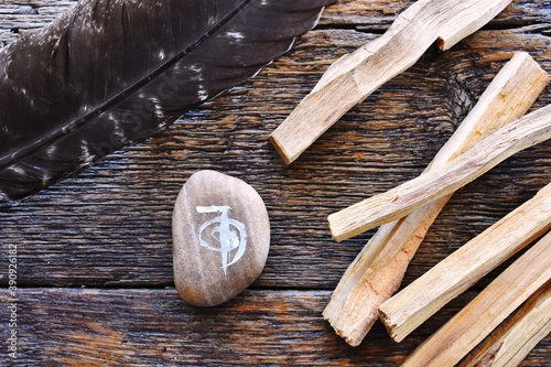 A top view image of a reiki healing symbol and palo santo smudge sticks on a dark wooden table top.  photo