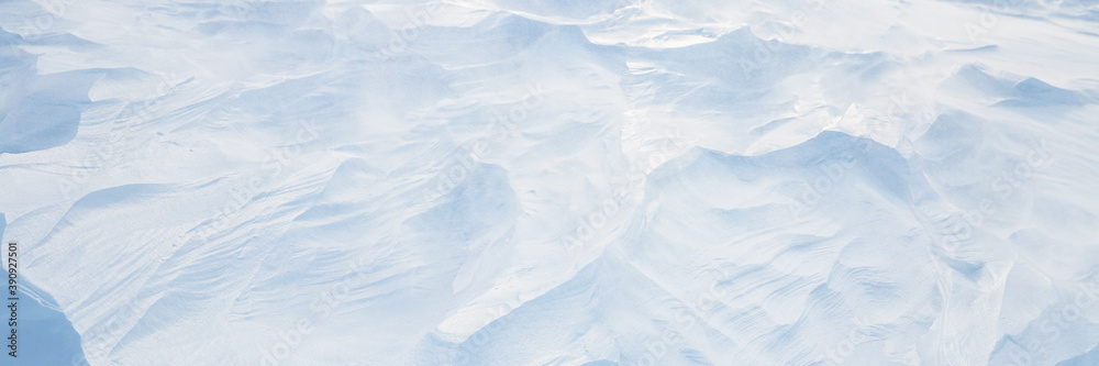 Beautiful winter background with snowy ground. Natural snow texture. Wind sculpted patterns on snow surface. Arctic, Polar region. Beautiful winter background with snowy ground. Natural snow texture. Wind sculpted patterns on snow surface. Arctic, Polar region.