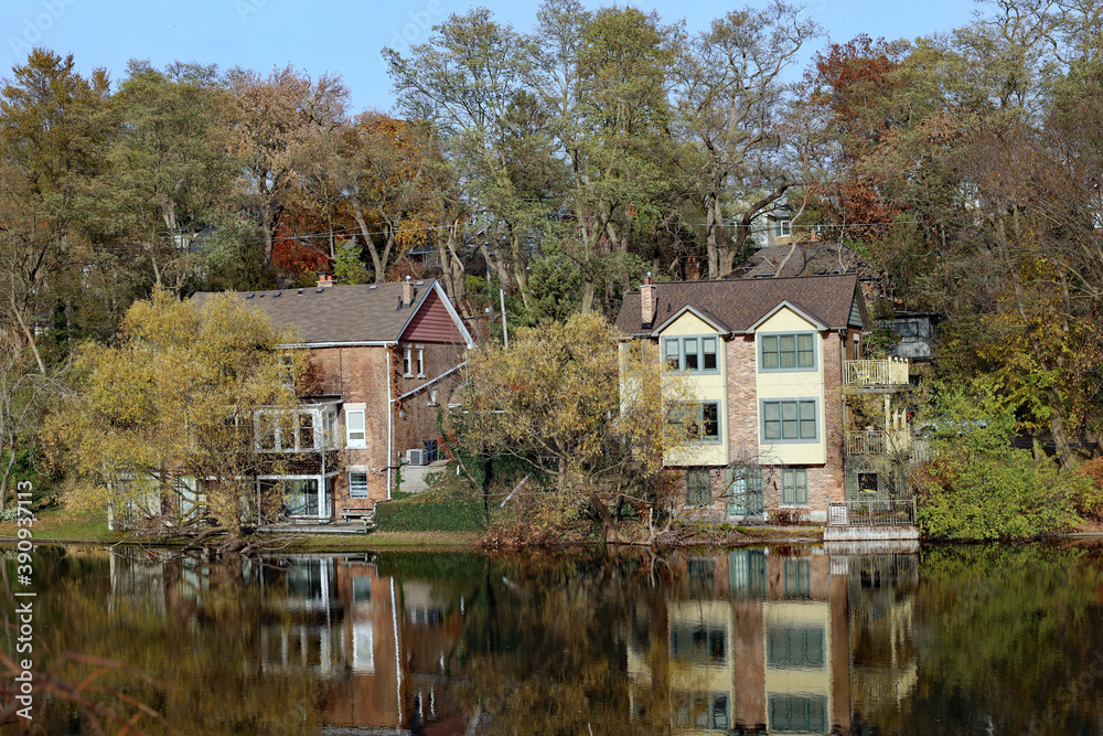 Residential neighborhood beside a pond with houses reflected in the water Residential neighborhood beside a pond with houses reflected in the water
