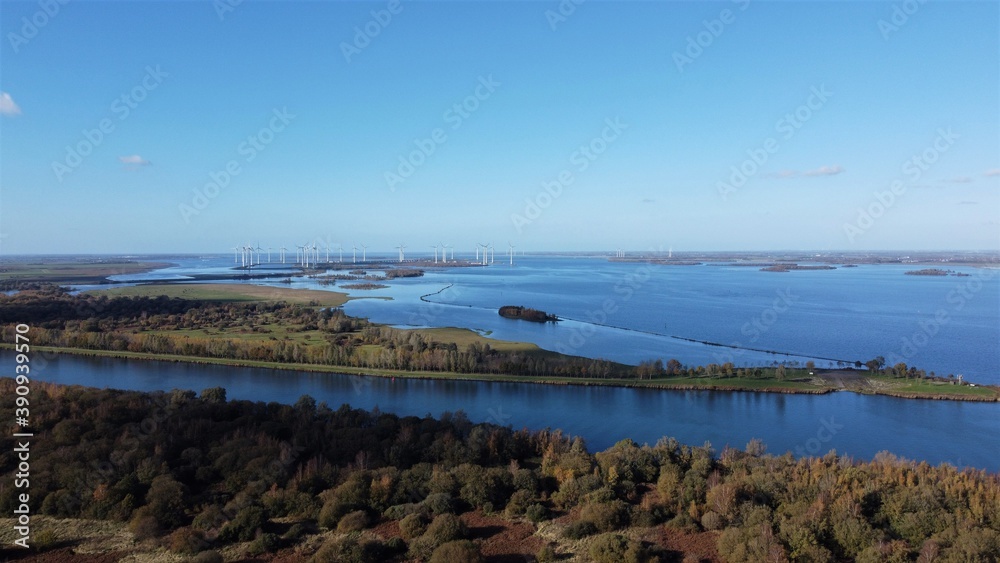 Nature view with wind turbines farm. Over water seen from the air.