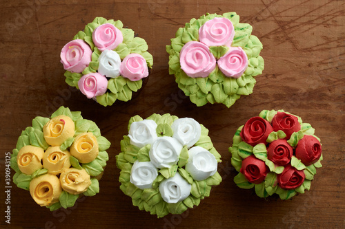 cupcakes decorated with rose design chantilly, placed on a wooden base © Michelle